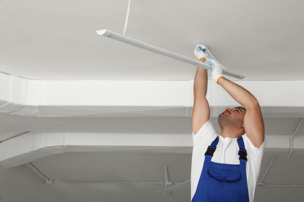Electrician installing ceiling light