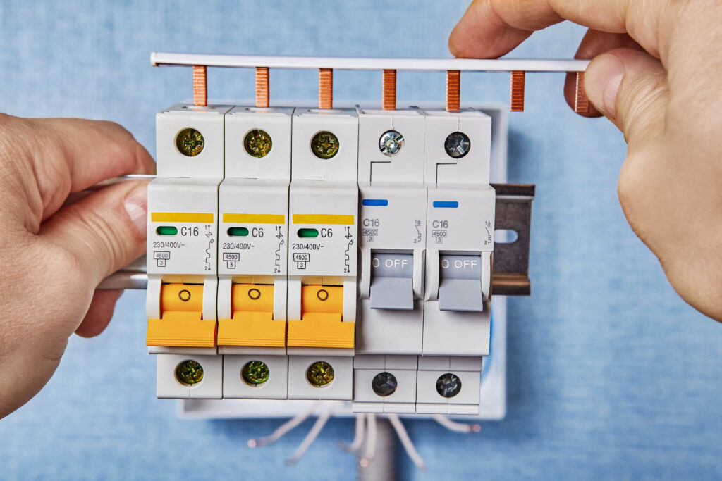 Electrician installing new circuit breaker in panel